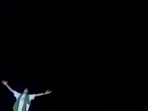 figure with arms outstretched in the dark